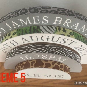 Puede incluir: Un arco de madera gris, blanco y marr&oacute;n para hitos de beb&eacute; con un tema de animales de la selva. El arco est&aacute; decorado con patrones de estampado de leopardo, cebra y jirafa. El arco est&aacute; inscrito con el texto "Leo James Branton", "20th August 2021", "16.28 PM", "5 LB 5 OZ", y "THEME 5".