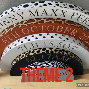 Puede incluir: Un conjunto de seis bloques de madera en forma de semic&iacute;rculo que se anidan con un tema de estampado de animales de safari. Los bloques est&aacute;n apilados en forma de arco&iacute;ris con el bloque superior que dice "Sonny Maxx Ferris 6th October 2020 7lb 15.5oz 02.17AM". El bloque inferior dice "THEME 2".