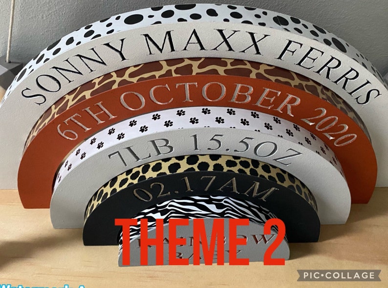Puede incluir: Un conjunto de seis bloques de madera en forma de semic&iacute;rculo que se anidan con un tema de estampado de animales de safari. Los bloques est&aacute;n apilados en forma de arco&iacute;ris con el bloque superior que dice "Sonny Maxx Ferris 6th October 2020 7lb 15.5oz 02.17AM". El bloque inferior dice "THEME 2".