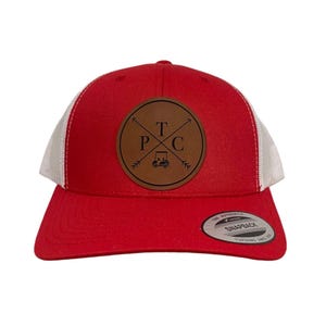 May include: Red and white trucker hat with a brown leather patch featuring the text "TPC" and a golf cart graphic.