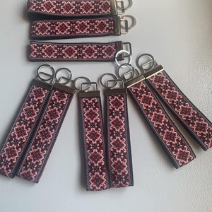 May include: Set of eight red, white and black patterned keychains with silver key rings.