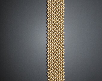 May include: A gold beaded bracelet with a woven pattern and silver clasps.