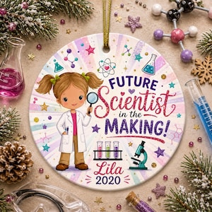 May include: A round ceramic ornament featuring a cartoon girl in a lab coat holding a magnifying glass. The ornament reads "Future Scientist in the Making!" with the name "Lila" and the year "2020". The design includes science-themed graphics.