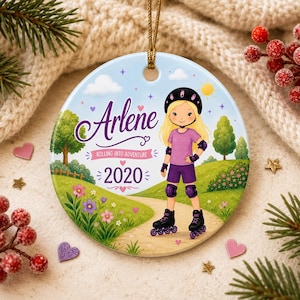 May include: A round ceramic ornament with a light blue background features a cartoon girl in roller skates. The girl wears a helmet, purple shorts, and a pink shirt. The name "Arlene" is written above the text "Rolling into Adventure 2020".