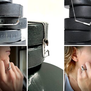 May include: A set of three silver hockey stick necklaces on black hockey pucks. The necklaces feature a silver hockey stick pendant. The pucks are stacked on top of each other.