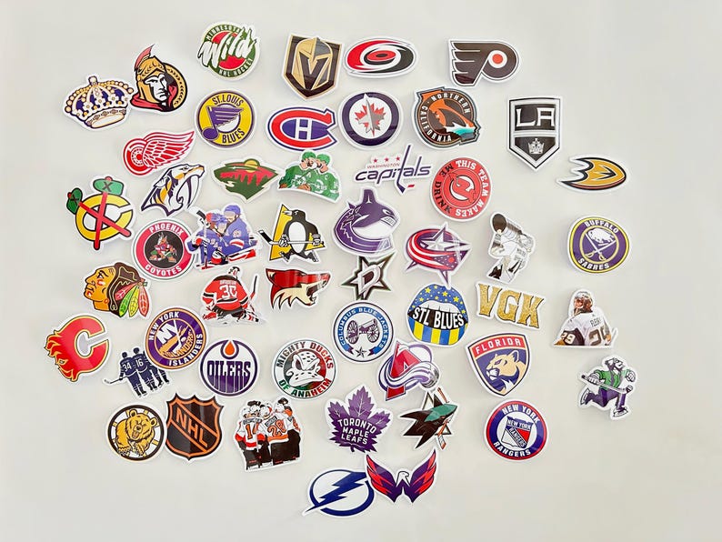 May include: A collection of colorful hockey team logo stickers. The stickers feature logos from teams like the Capitals, Blues, Oilers, Maple Leafs, and Rangers. The stickers are perfect for decorating laptops, water bottles, or anything else you can think of.