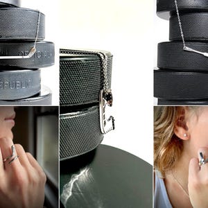 K&ouml;nnte beinhalten: Ein Set an Hockeyschl&auml;ger-Schmuck, bestehend aus einer Halskette, einem Ring und Ohrringen. Der Schmuck wird auf Hockeyscheiben pr&auml;sentiert.