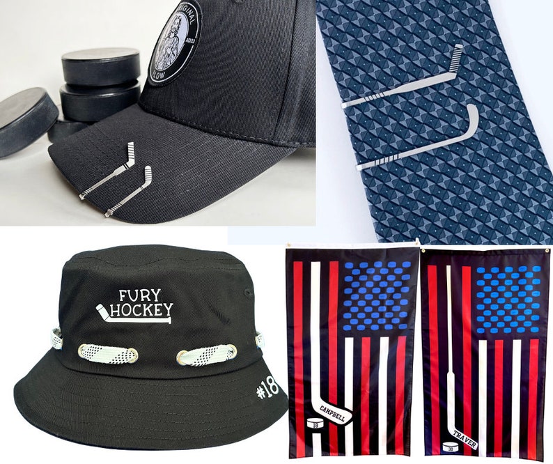 May include: A black baseball cap with a white logo that says "Fury Hockey" and a hockey stick graphic. The cap has a white band with a pattern and a white number "18" on the side. There are two silver hockey stick tie clips on the cap. There are also two American flag designs with hockey sticks and the names "Campbell" and "Traver" on them.