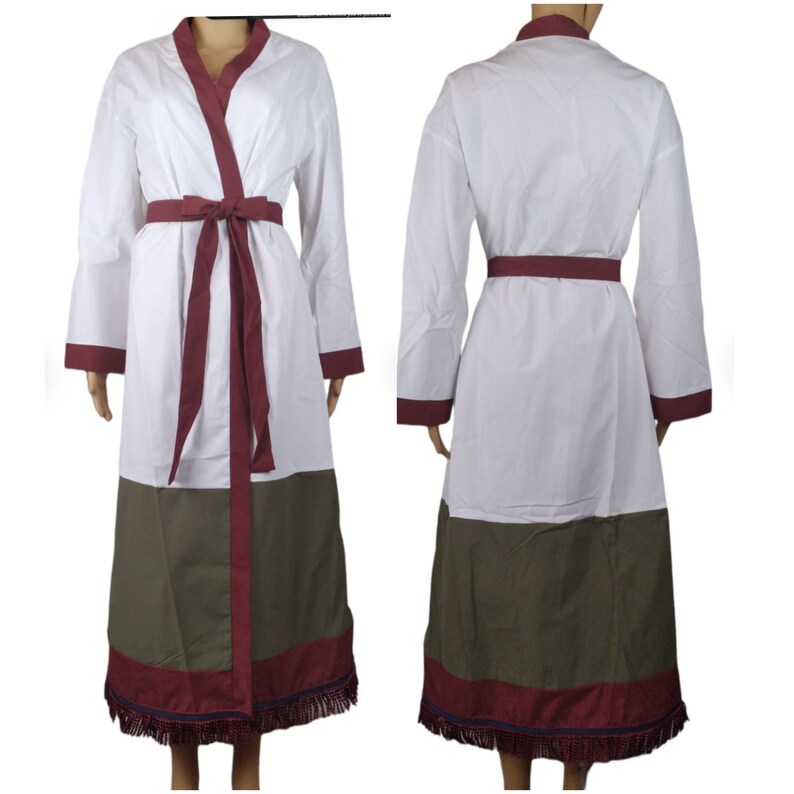 May include: White robe with long sleeves, a burgundy belt, and trim. The robe has a V-neck and a color block design with a green lower section. The hemline features a burgundy border with fringe.