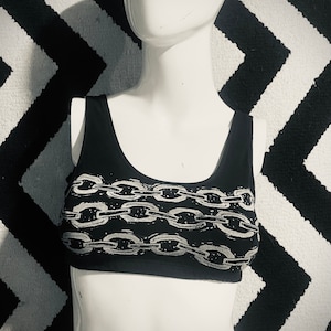 May include: Black tank top with a white chain print design.