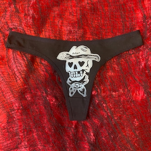 Puede incluir: Bóxer de algodón negro con un estampado gráfico de una calavera blanca con un sombrero de vaquero.