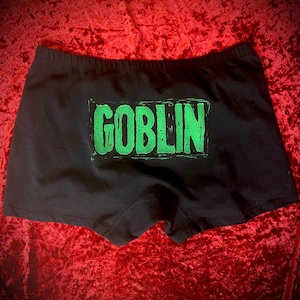 以下が含まれることがあります： 緑色の「GOBLIN」のグラフィックプリントが施された黒い下着