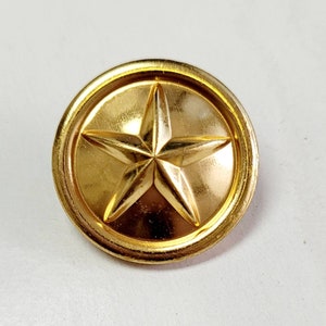 May include: A gold-coloured metal button with a five-pointed star design.
