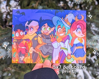 May include: A 5x7 inch postcard print featuring five cartoon characters in Halloween costumes. The characters are a purple-haired witch, a green-haired wizard, a white-haired vampire, a red-haired werewolf, and a blue-haired ghost. The background is a dark blue night sky with stars and a full moon.