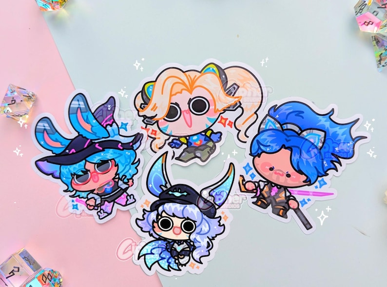 May include: Four colorful cartoon character stickers with blue, pink, and white accents. The characters are wearing different outfits and have unique expressions.