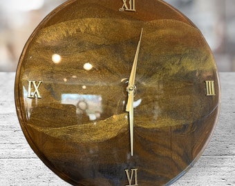 Elegante reloj de ondas doradas de resina epoxi hecho a mano sobre madera. 12" con números romanos. Reloj de pared