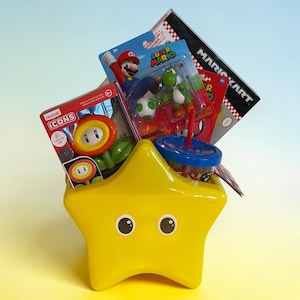 K&ouml;nnte beinhalten: Ein gelber sternf&ouml;rmiger Beh&auml;lter gef&uuml;llt mit Spielzeug und Waren zum Thema Super Mario. Enth&auml;lt eine Mario-Figur, eine Yoshi-Figur, eine leuchtende Blume und ein Mario Kart-Spiel. Der Beh&auml;lter hat zwei schwarz-wei&szlig;e Augen.
