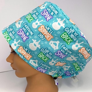 May include: A blue scrub hat with a white spine graphic and the text "We've got your back" and "Everything will be spine" repeated.