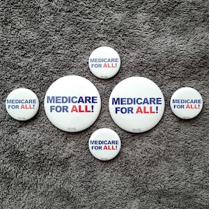 May include: Five white round buttons with the text "Medicare for All!" in blue and red lettering.