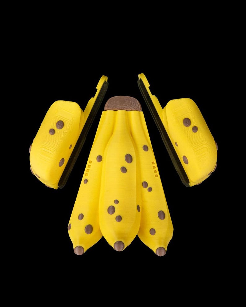 K&ouml;nnte beinhalten: Eine Ansammlung gelber, bananenf&ouml;rmiger Objekte mit braunen Flecken und Spitzen, vor schwarzem Hintergrund. Die Objekte haben ein strukturiertes Aussehen und sind in einer ansprechenden Komposition angeordnet, die ein spielerisches oder k&uuml;nstlerisches Thema suggeriert.