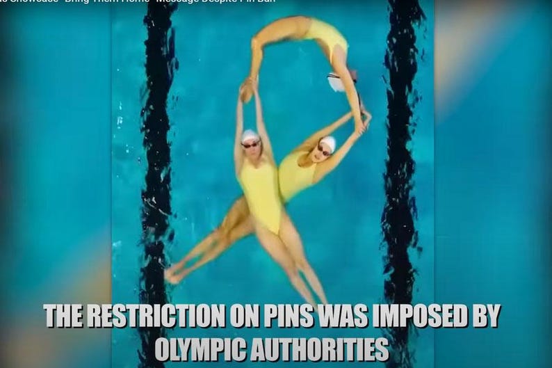 Puede incluir: Tres nadadoras sincronizadas con trajes de ba&ntilde;o amarillos realizan una rutina en una piscina azul. Las nadadoras est&aacute;n en una formaci&oacute;n que se asemeja a la letra 'P'. El texto "THE RESTRICTION ON PINS WAS IMPOSED BY OLYMPIC AUTHORITIES" est&aacute; en la parte inferior de la imagen.