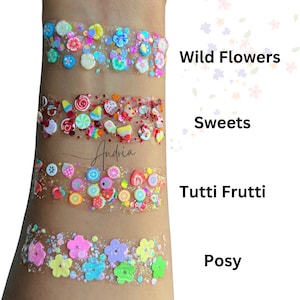 May include: Four rows of colorful glitter glue with different themes: Wild Flowers, Sweets, Tutti Frutti, and Posy. Each row features a variety of colorful glitter and small, decorative shapes.