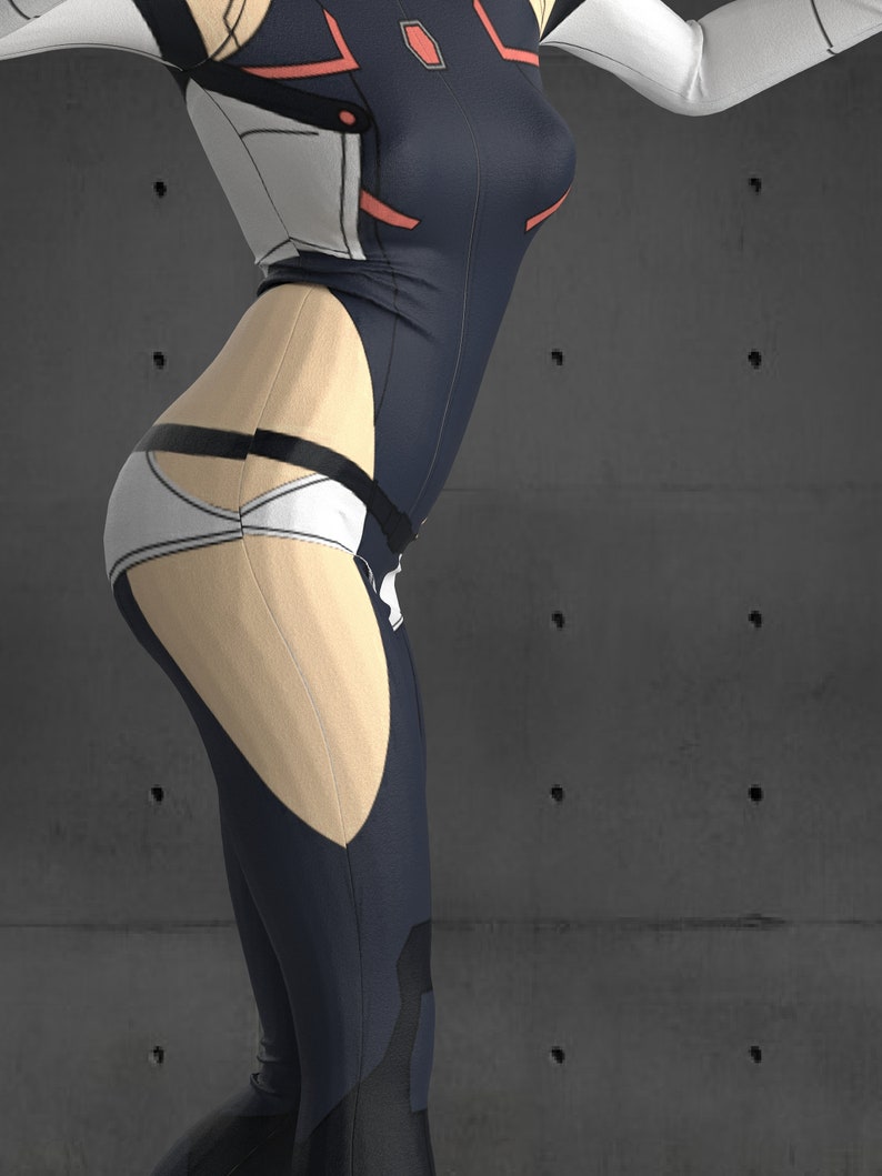 May include: A woman wearing a black and white jumpsuit with red accents. The jumpsuit has a white belt and a white panel on the back. The woman is standing in front of a gray concrete wall.