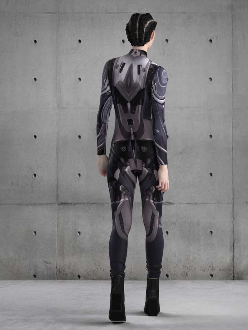 Puede incluir: Un mono de cuerpo entero con un dise&ntilde;o futurista en tonos grises y negros. El traje presenta paneles y detalles detallados, creando una est&eacute;tica tecnol&oacute;gica. El modelo lleva botas negras.