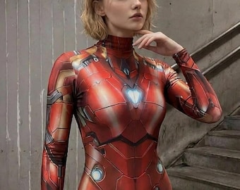 May include: A long-sleeved bodysuit featuring a printed red and gold metallic armor design with a high neckline and a central glowing blue arc reactor graphic on the chest, mimicking the appearance of a robotic suit of armor.