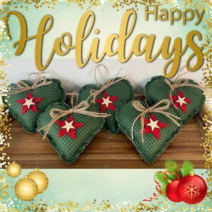 May include: Five heart-shaped fabric ornaments in dark green with white polka dots. Each heart features a red felt star topped with a smaller white wooden star and a jute twine bow. The text Happy Holidays is displayed in gold script above.