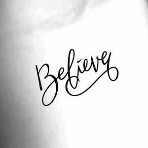May include: Black and white image featuring the word "Believe" in elegant cursive script. The word is the focal point, set against a soft, blurred background. The design is simple yet impactful.