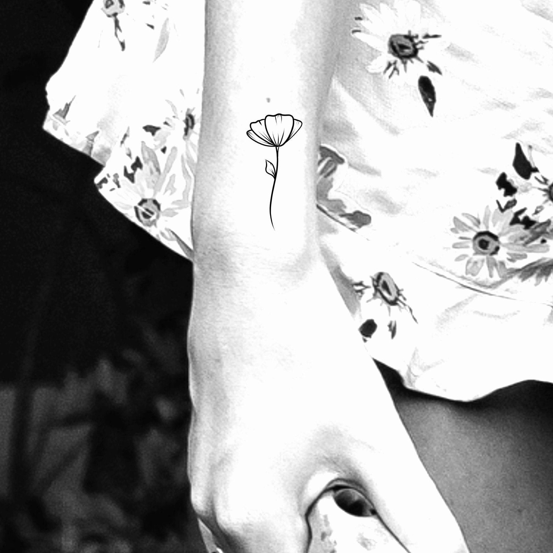 Tiny poppy tattoo located on the pelvis fine line