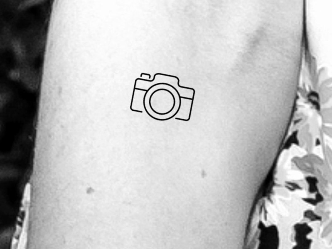 Tiny minimalistic camera tattooed on the finger.