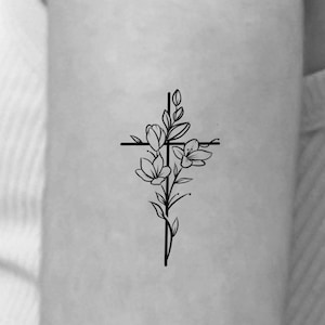 May include: A simple black line drawing of a cross with flowers growing from the center.