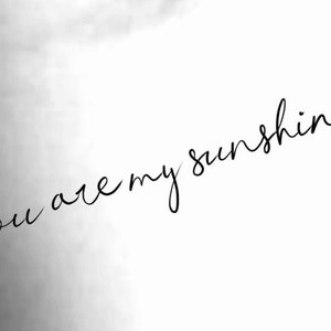 May include: Black and white image with the text "you are my sunshine" written in cursive.