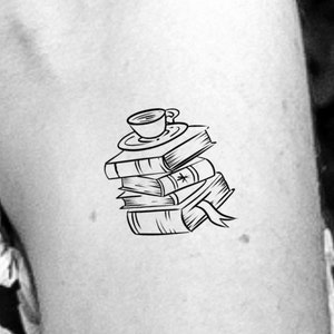 May include: A black and white line drawing of a stack of books with a cup of coffee on top. The books are stacked on top of each other and the cup of coffee is sitting on top of the stack.