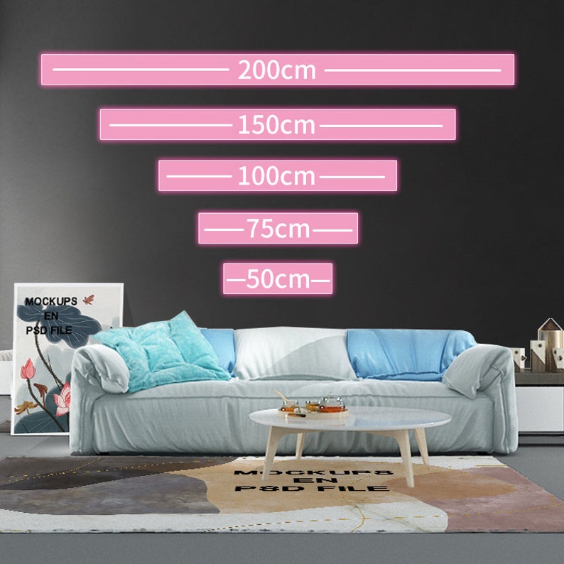 Puede incluir: Un sof&aacute; azul claro con dos almohadas y una mesa de caf&eacute; blanca delante de &eacute;l. Una alfombra con un dise&ntilde;o abstracto marr&oacute;n, gris y blanco est&aacute; en el suelo. La pared detr&aacute;s del sof&aacute; es gris y tiene l&iacute;neas rosas con medidas en cent&iacute;metros: 200 cm, 150 cm, 100 cm, 75 cm y 50 cm.