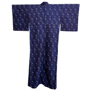 Puede incluir: Un kimono azul oscuro con un patrón geométrico blanco. El kimono está hecho de una tela suave y ligera y tiene un diseño japonés tradicional.