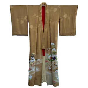 May include: A gold kimono with a floral pattern. The kimono has a red lining and is decorated with white, pink, and blue flowers.