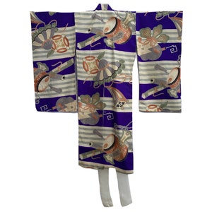 Puede incluir: Un kimono japonés tradicional con un fondo a rayas morado y blanco. El kimono está decorado con un patrón colorido de tambores, flores y otros motivos tradicionales japoneses.