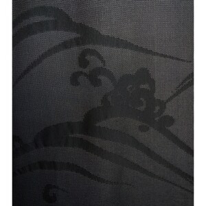 May include: Close-up of a black fabric with a wave-like pattern. The design features flowing lines and stylized floral elements, creating a textured, dark aesthetic. The fabric has a subtle sheen.