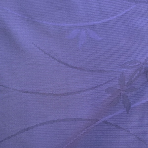 Pode incluir: Um close-up de um tecido roxo com um padrão tecido sutil. O tecido tem um design delicado, quase floral.