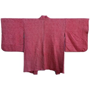 May include: A red Japanese kimono with a textured pattern. The kimono is made of a soft, lightweight fabric and has a traditional design.