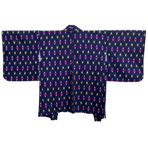 Puede incluir: Un kimono azul marino con un patrón geométrico blanco, rosa y amarillo.