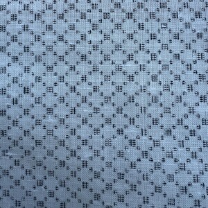 May include: A close-up of a white fabric with a black geometric pattern. The pattern is made up of small squares and rectangles.