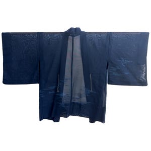 May include: A navy blue kimono with a sheer, mesh-like fabric. The garment features long sleeves and a landscape design in shades of blue. The kimono is spread out, showcasing its full shape and design.