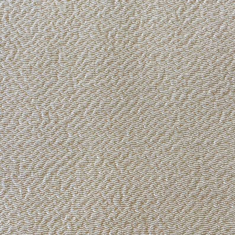 May include: Close-up of a beige fabric with a textured woven pattern.