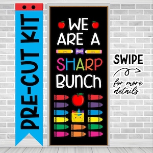 May include: A black chalkboard door sign with the text "We are a sharp bunch" in white. The sign is decorated with red apples, crayons, and a box of crayons with a smiling face. A blue banner with the text "Pre-cut kit" is on the left side of the image. A white sticker with the text "Swipe for more details" is on the right side of the image.