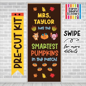 May include: A brown rectangular door decoration kit featuring the text "MRS. TAYLOR has the SMARTEST PUMPKINS in the patch!" decorated with cartoon acorns, a squirrel, a pumpkin, an axolotl, and colorful autumn leaves in yellow, orange, and red.