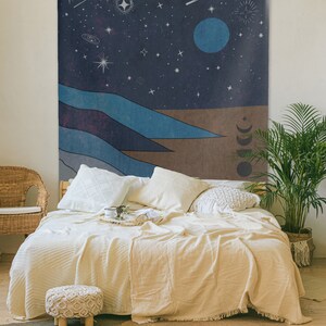 May include: A tapestry featuring a night sky with stars, a crescent moon, and a large blue planet. The bottom of the tapestry depicts a landscape of blue and brown hills.